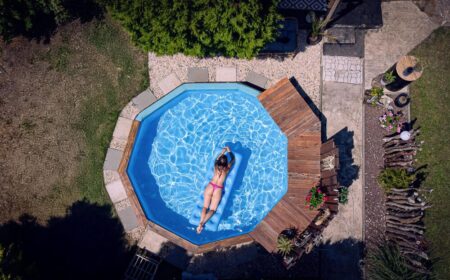 Frau im Bikini liegt auf einer Luftmatratze in einem runden Gartenpool, Luftaufnahme von oben – Drohnen-Shooting vom Fotograf in Gera